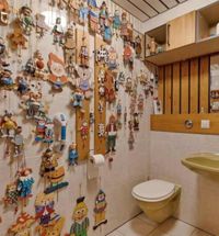 Gedateerd toilet met schrootjes met allerlei decoratieve objecten aan de wand