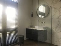 Badkamer met badkamermeubel met marmeren achterwand en wastafelkom
